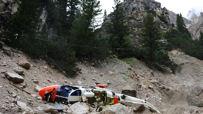 20090822 - CORTINA D'AMPEZZO - BELLUNO - DIS - PRECIPITA UN ELICOTTERO DEL 118: QUATTRO MORTI NEL BELLUNESE. L'elicottero del Suem precipitato questo pomeriggio 22 agosto 2009. La procura ..della Repubblica di Belluno ha aperto un fascicolo d'inchiesta sulla caduta dell'elicottero del Suem di Pieve di Cadore che ha provocato la morte delle quattro persone a bordo. L'elicottero stava intervenendo per una verifica nella zona di Rio Gere, tra il monte Cristallo e il Faloria, dove si era staccata una frana che aveva invaso un tratto stradale. Durante una manovra, sul versante del Cristallo, eseguita forse in seguito anche al maltempo, il velivolo avrebbe toccato i fili della tensione ed e' quindi precipitato...ANSA/EMILIO ZANGIACOMI POMPANIN/DRN I resti dell'elicottero dopo lo schianto al suolo