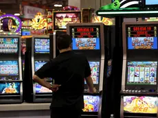 Un uomo gioca con una slot machine in una foto d'archivio. ANSA / YM YIK .