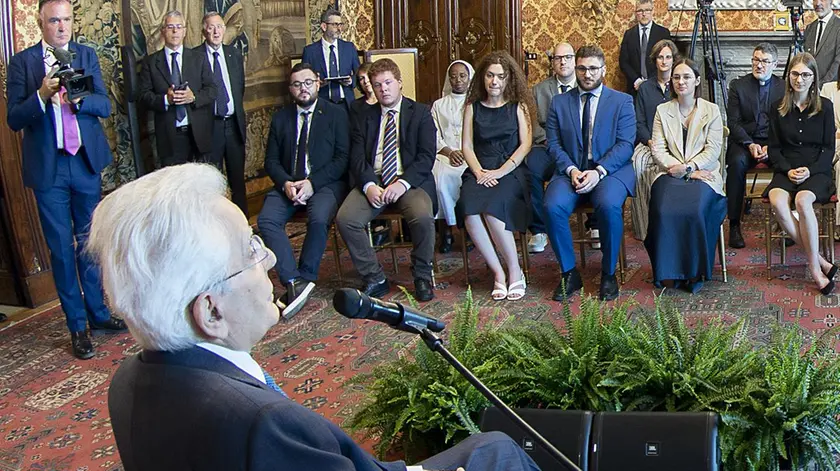 Mattarella in primo pianto: seduto di fronte con i capelli rossi c’è Samuel Basei
