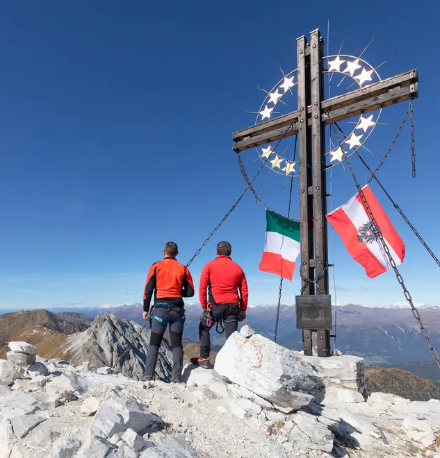 the peak of the mount cavallino (Gr. Kinigat) on the border between Italy and Austria with the cross of Europe and the flags of the two neighboring states, Kartitsch, Carnic alps, Europe