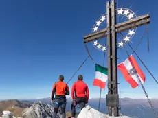 the peak of the mount cavallino (Gr. Kinigat) on the border between Italy and Austria with the cross of Europe and the flags of the two neighboring states, Kartitsch, Carnic alps, Europe