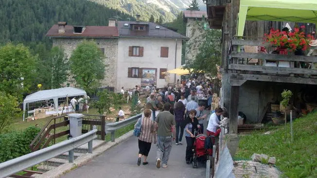 - La piazza della frazione di Masare' e una delle vie di Cibiana affollate di visitatori per i Murales viventi