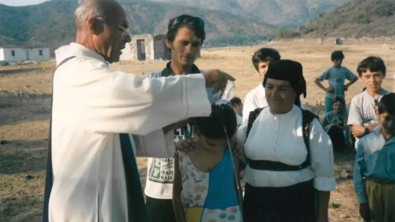 Don Fabio Cassol celebra un battesimo all'aperto durante la sua missione in Albania nel 1998