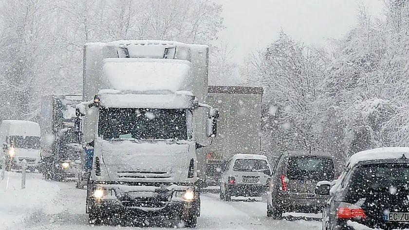 Traffico di mezzi pesanti e automobili lungo l’Alemagna durante una nevicata