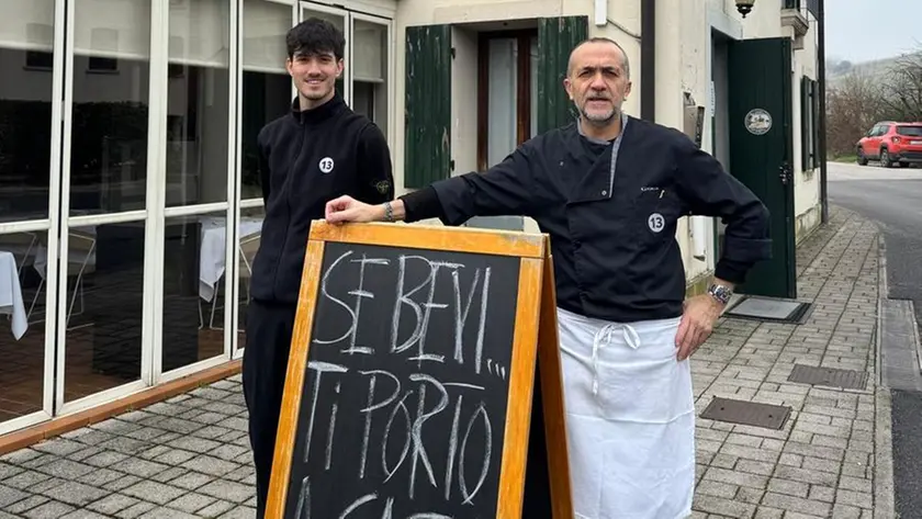 Padre e figlio con la lavagna che annuncia l’offerta per i clienti