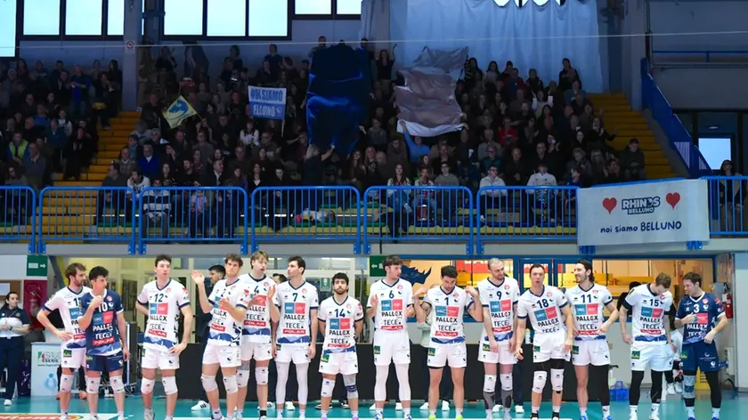 Il Belluno Volley con sullo sfondo i tifosi della VHV Arena