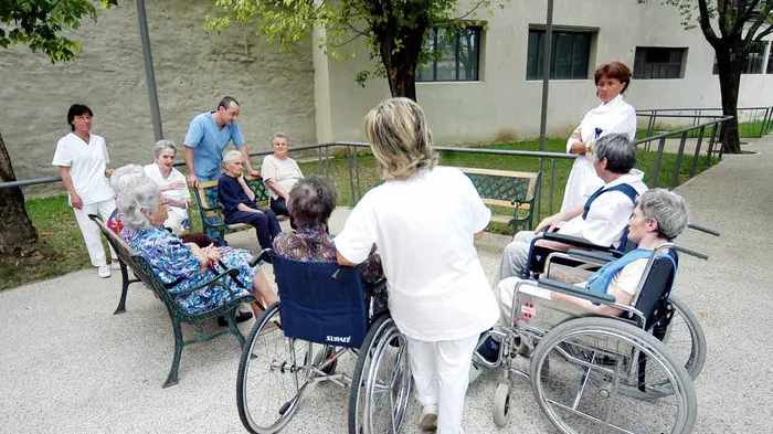 Anziani di una casa di riposo con gli operatori sociosanitari