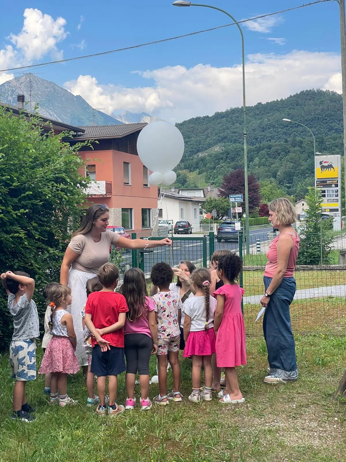 I bambini con le maestre prima del lancio del palloncino bianco