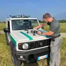 Agente di polizia provinciale con un drone per verificare la presenza di fauna selvatica nei campi