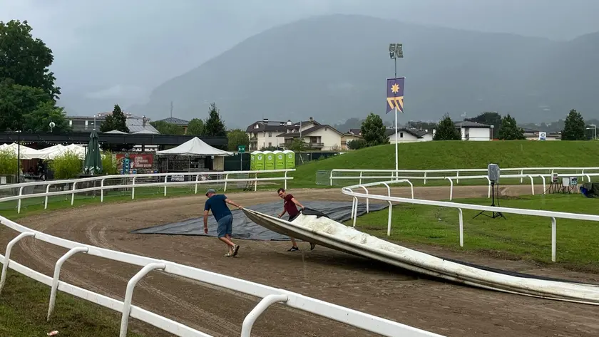 La posa dei teli antipioggia sulla pista della corsa dei cavalli a Pra’ del Moro nel punto più basso