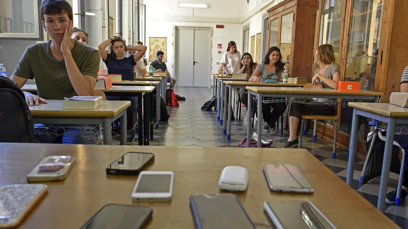 Gli smartphone lasciati sulla cattedra durante un esame di maturità. Foto Frassineti / AGF