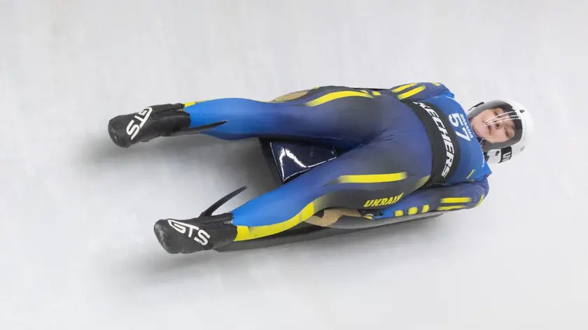 Un'atleta dello slittino mentre scende lungo il tracciato dello Sliding centre