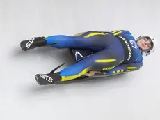 Un'atleta dello slittino mentre scende lungo il tracciato dello Sliding centre