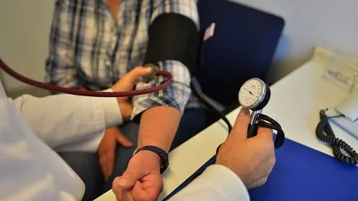 Un medico di base visita un paziente nel suo ambulatorio