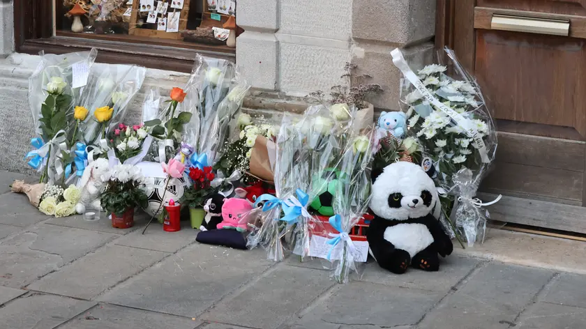 Gli omaggi in memoria del piccolo Giovanni sotto la casa teatro dell'omicidio a Muggia (Lasorte)