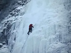Un alpinista mentre arrampica sul ghiaccio