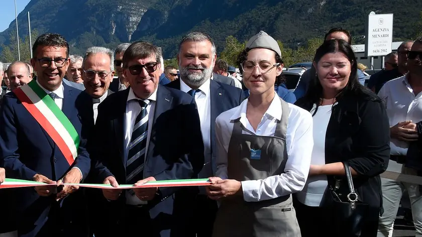 Elisa De Paris, con berretto e occhiali, regge il nastro tricolore all'inaugurazione del Bar Bianco di Lattebusche a Faè di Longarone