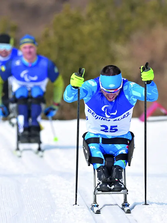 Giuseppe Romele in azione in una gara di sci di fondo paralimpico, nel riquadro Marco Giunio De Sanctis