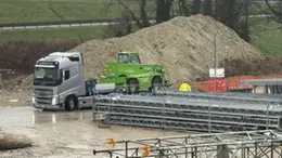 I tir portano via i macchinari dal cantiere della bretella (Foto Porcile)