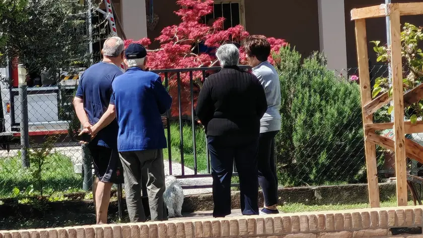 I vicini di casa davanti al condominio della tragedia (foto Pòrcile)
