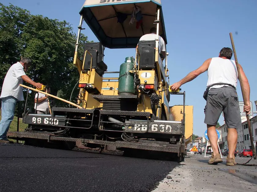 Operai al lavoro per l'asfaltatura di una strada