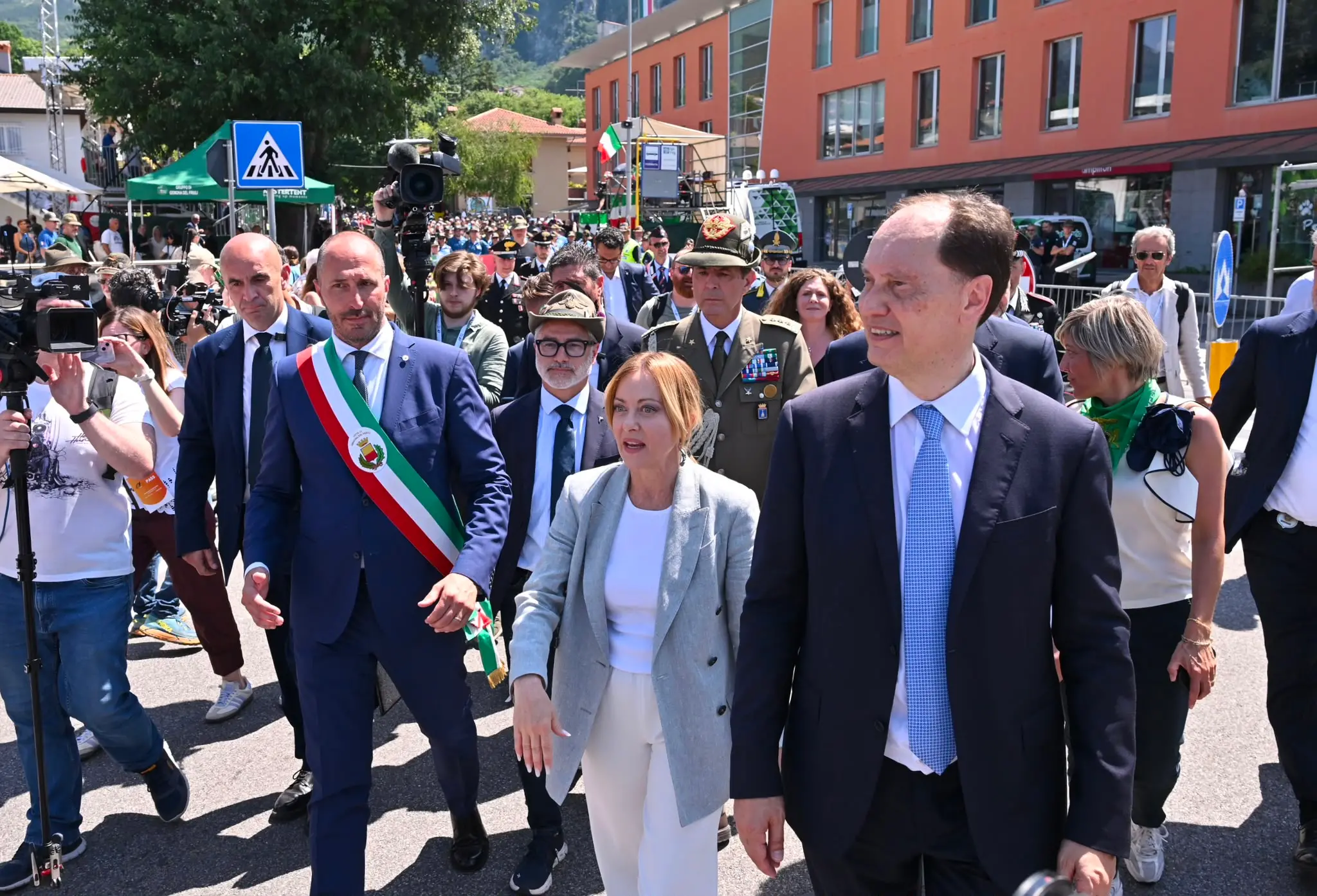 Accolta dagli applausi e dai cori della folla, la presidente del Consiglio Giorgia Meloni ha partecipato oggi al raduno del Triveneto degli alpini a Gemona, lasciando poi l’evento tra gli applausi dei presenti. «C’era bisogno di questo bagno di patriottismo», ha dichiarato la premier mentre attraversava l’area della manifestazione salutando il pubblico. «Non sono riuscita ad andare a Genova quindi penso che valesse la pena venire qui per dire grazie», ha aggiunto Meloni. «Grazie per i valori e grazie per un lavoro preziosissimo anche durante le nostre Olimpiadi e per il lavoro che fanno da volontari costantemente. Sono una certezza e per le istituzioni avere questo genere di certezze fa assolutamente la differenza».