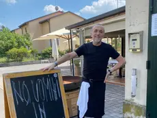 La lavagna con il divieto posta all'ingresso del locale