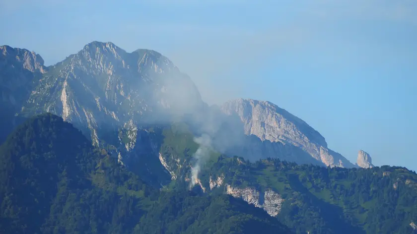 Il fumo dell'incendio boschivo sviluppatosi sul monte Palmar, sopra Cesiomaggiore