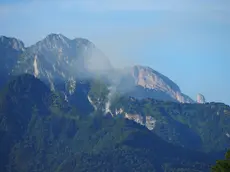 Il fumo dell'incendio boschivo sviluppatosi sul monte Palmar, sopra Cesiomaggiore
