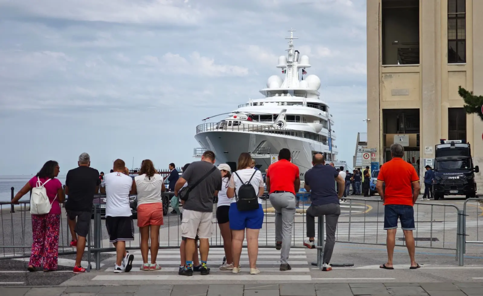 I curiosi dietro le transenne osservano lo yacht. Foto Lasorte