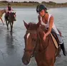 Belen cade da cavallo sulla spiaggia