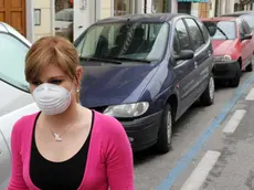 Una ragazza con mascherina anti - smog.