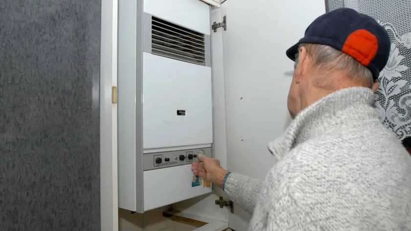 Un tecnico controlla in un appartamento una caldaia per il riscaldamento