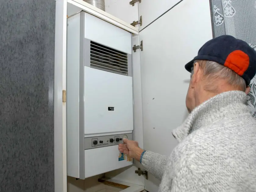Un tecnico controlla in un appartamento una caldaia per il riscaldamento