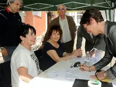 Costanzo davanti al manifesto che spiega come saranno la spiaggia e l’area ricreativa