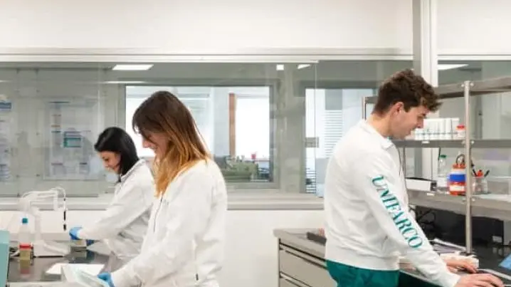 Giovani al lavoro nel laboratorio controllo qualità di Unifarco