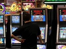 Un uomo gioca con una slot machine in una foto d'archivio. ANSA / YM YIK .