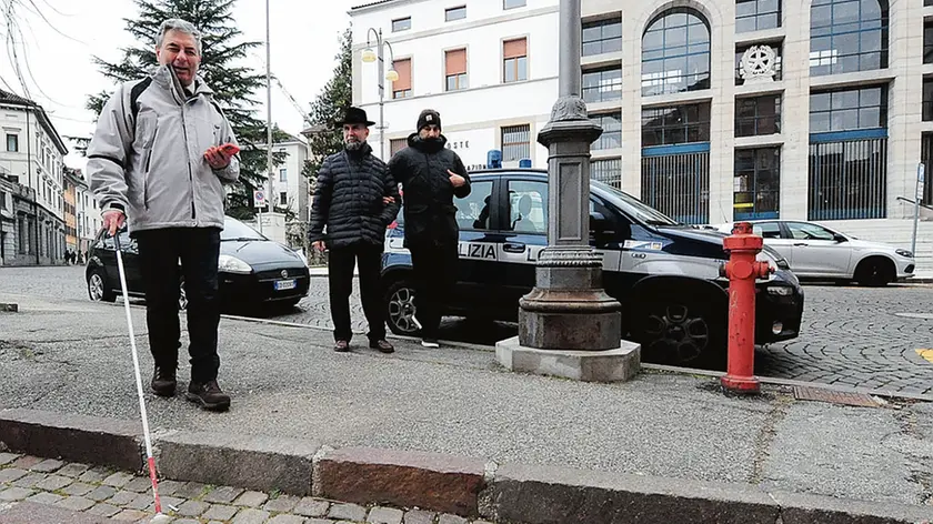 Non vedenti alle prese con un difficile passaggio davanti al Palazzo delle Poste a Belluno