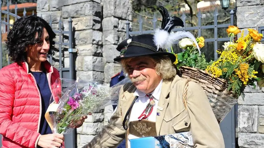La moglie del presidente del Consiglio Matteo Renzi, Agnese, esce di casa e saluta 'il barone delle nevi', Giuseppe Rudatis, un personaggio folcloristico di Belluno che, vestito alla tirolese, voleva consegnare dei fiori a Renzi per la moglie e le donne del Governo, Pontassieve 02 marzo 2014..Quando Agnese è uscita di casa, il 'barone' è riuscito a darle un'orchidea e un libro. ANSA/MAURIZIO DEGL INNOCENTI.