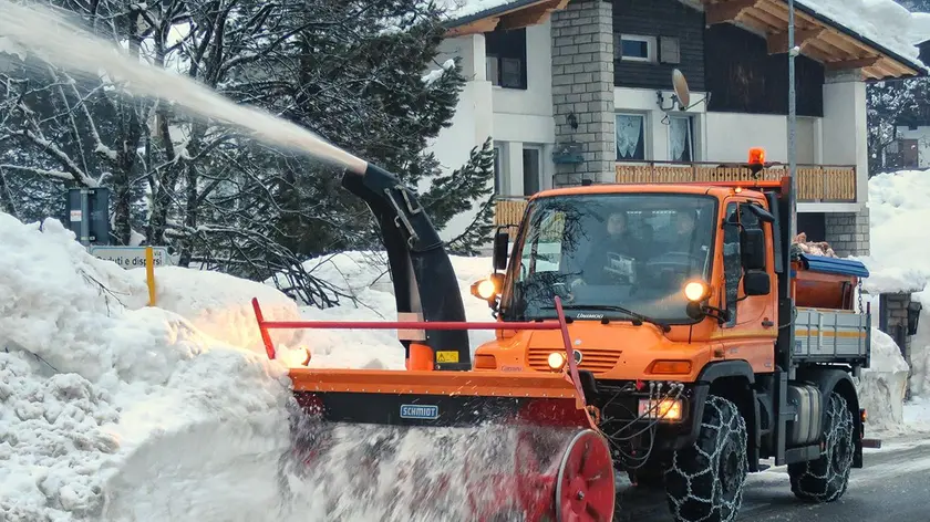 Un Unimog attrezzato per lo sgombero neve in servizio su una strada bellunese