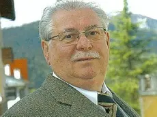 Sopra Gino Mondin presidente del Consorzio Dolomiti a lato turisti girano per la via principale di Cortina