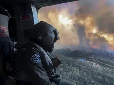 21/12/2019 Blue Mountains, National Park, Nuovo Galles del Sud, nell'area delle Montagne Blu gli incendi continuano a distruggere i boschi causando danni ingenti a persone e animali, nella foto un militare su un elicottero dell'esercito in ricognizione *** Local Caption *** The Australian Defence Force (ADF) is continuing to support Emergency Management Australia in firefighting efforts around the country. Navy’s MRH-90 Taipan helicopters based at HMAS Albatross in Nowra have evacuated residents at risk on the New South Wales South Coast and continue with day and night time aerial fire mapping. An additional MRH-90 forward-deployed to western Sydney, has facilitated access by specialist RFS personnel to properties under threat from advancing fire in the Hartley Vale region. The helicopter was also tasked to support personnel evacuation and property assessment in the Blue Mountains – Lithgow region. ADF liaison officers are working side by side with emergency services personnel in the State Disaster Coordination Centre (SDCC) and within the New South Wales Rural Fire Service Headquarters. Defence is also providing transport and other capabilities such as aviation ground support, logistics, engineering and accommodation to support the firefighting effort.