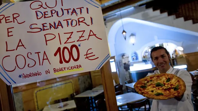 Un cartello in una pizzeria del centro storico di Napoli annuncia che dal 27 ottobre 2011 la pizza per i deputati ed i senatori costa 100 euro. Ieri sera il deputato del Pd Sergio D'Antoni ha pagato 100 euro per una pizza ''salsiccia e friarielli '' nella pizzeria Sorbillo, Napoli, 29 ottobre 2011. L'ex leader della Cisl è stata la prima vittima dell'iniziativa anti casta messa in campo a Napoli dal commissario regionale dei Verdi Francesco Emilio Borrelli e dallo speaker radiofonico Gianni Simeoli con la complicità di una nota pizzeria dei Decumani dove da alcuni giorni la pizza costa cara (100 euro) se a mangiarla è un rappresentante della cosiddetta casta. ANSA / CIRO FUSCO
