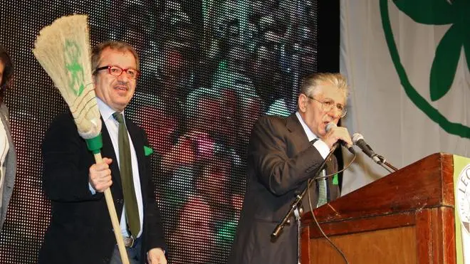Il leader della Lega Nord Umberto Bossi (D) e Roberto Maroni sul palco alla Festa dell'Orgoglio Padano alla Fiera di Bergamo, 11 aprile 2012. Maroni tiene in mano una scopa. "Dobbiamo fare pulizia, dobbiamo rimediare alla violazione del nostro codice morale. E' intollerabile. La Lega e' diversa dagli altri partiti. Chi sbaglia paga, senza guardare in faccia nessuno" ha detto Maroni..ANSA/PAOLO MAGNI/