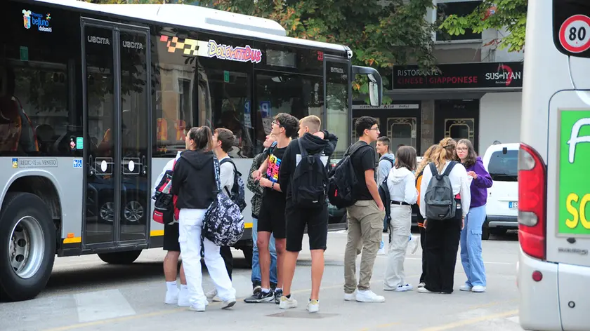 Studenti all'uscita da scuola mentre salgono su un pullman per tornare a casa