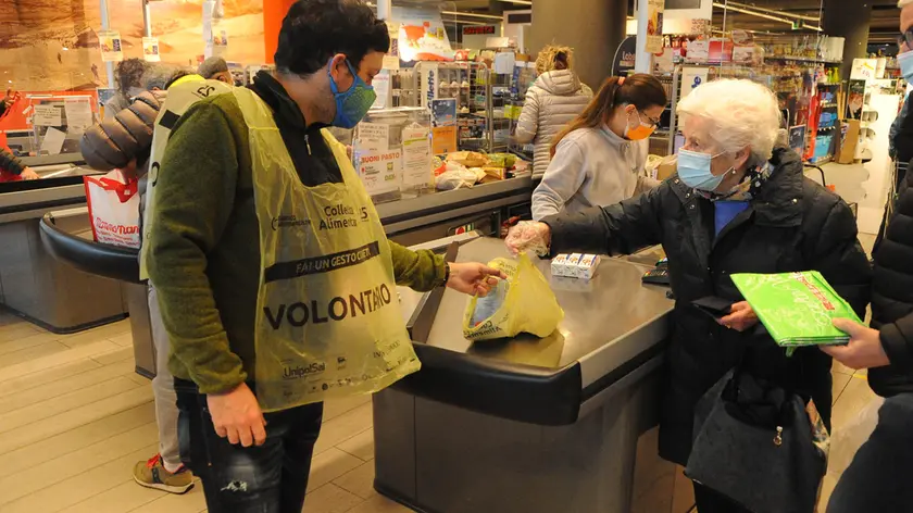 Un volontario del Banco alimentare veneto raccoglie le offerte di una signora durante la Colletta alimentare