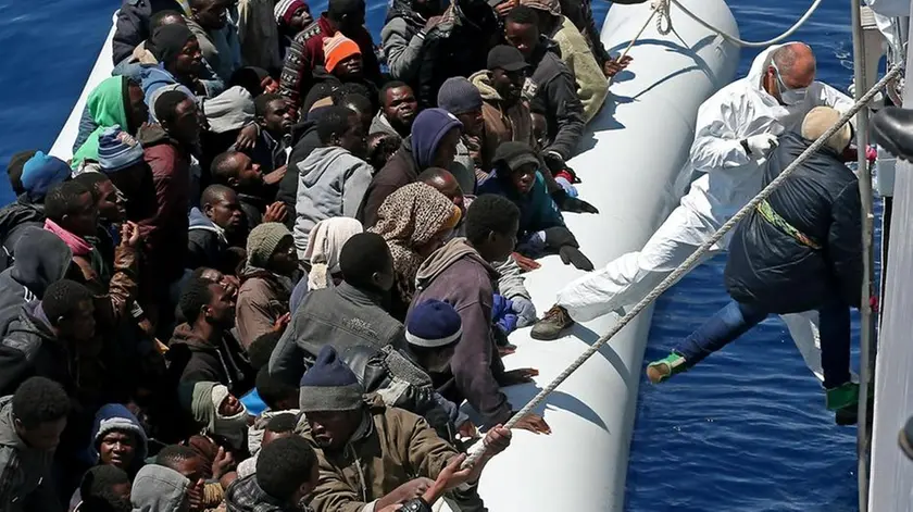 Personale di equipaggio della nave P.03 "Denaro" della guardia di finanza durante le operazioni di trasbordo di centinaia di migranti al largo delle coste libiche, Mar Mediterraneo 22 aprile 2015..ANSA/ALESSANDRO DI MEO