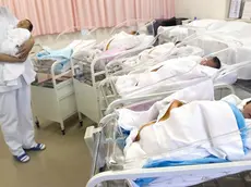 Una infermiera con in braccio un neonato in ospedale in una foto d'ARCHIVIO. ANSA