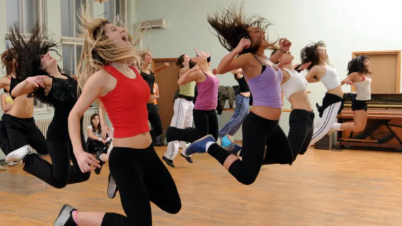 Young girls in the high jump practicing modern dance.