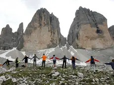 20090705 - TRE CIME DI LAVAREDO (DOLOMITI - MISURINA - BELLUNO) - HUM - G8: AFRICA, CATENA UMANA TRE CIME LAVAREDO PER SOLIDARIETA' - La catena umana attorno alle Tre Cime di Lavaredo questa mattina 05 luglio 2009. Piu' di 6 mila persone hanno partecipato oggi alla manifestazione 'Le Dolomiti abbracciano l'Africa', gigantesco girotondo attorno alle Tre Cime di Lavaredo, organizzato da varie associazioni no profit con lo scopo di inviare ai capi di governo del G8 un messaggio per l'Africa...ANSA / ANDREA SOLERO / DBA Una suggestiva immagine della , l'abbraccio alle Tre Cime